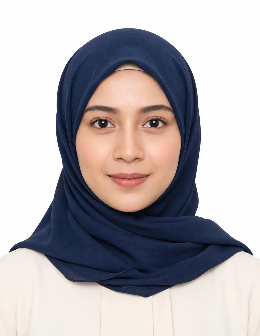 Hijab Passport Photo AI Prompt showing a woman wearing a navy-blue hijab and cream blouse, facing the camera against a plain white background with soft studio lighting.
